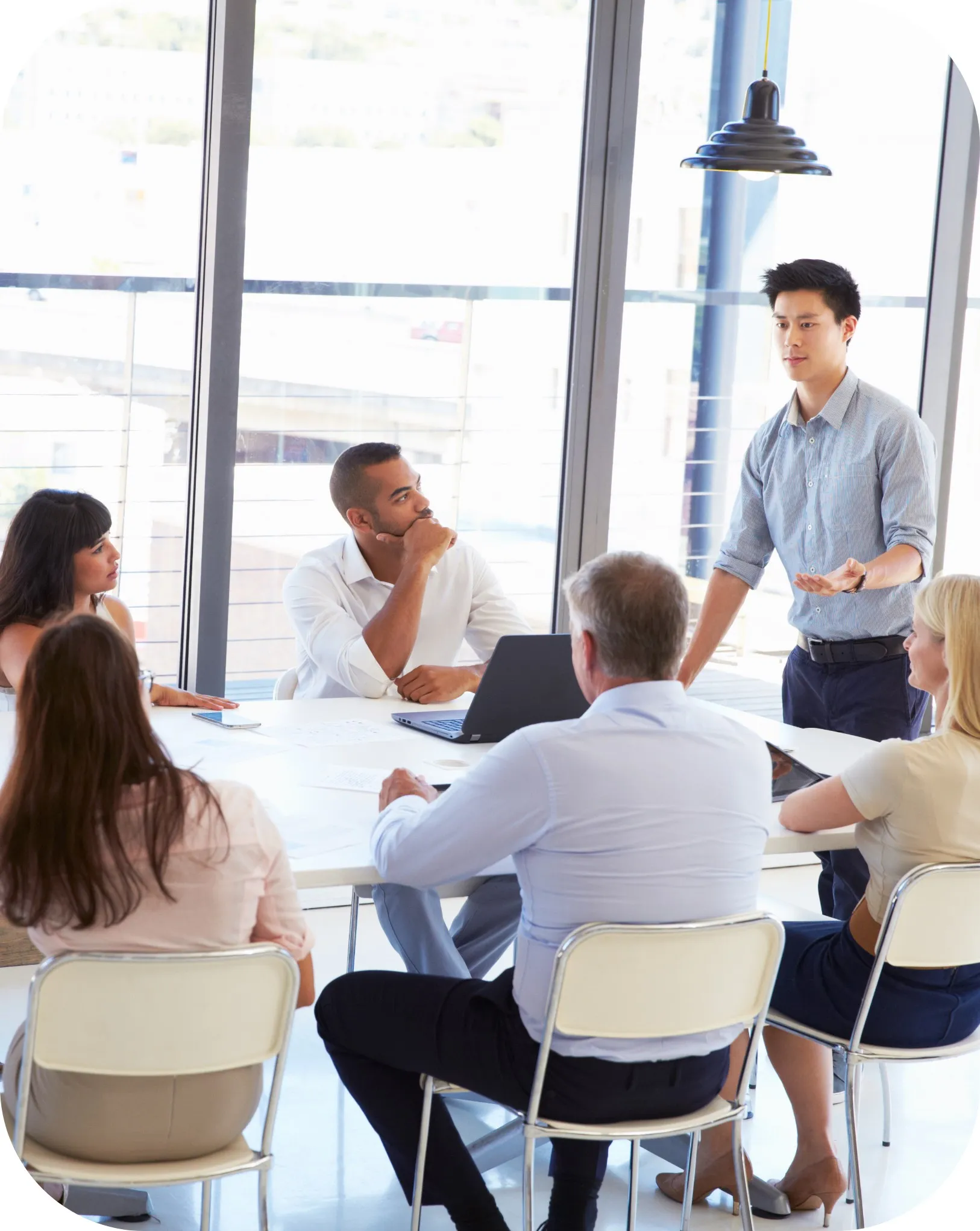 A picture of a group of people having a meeting around a office table.