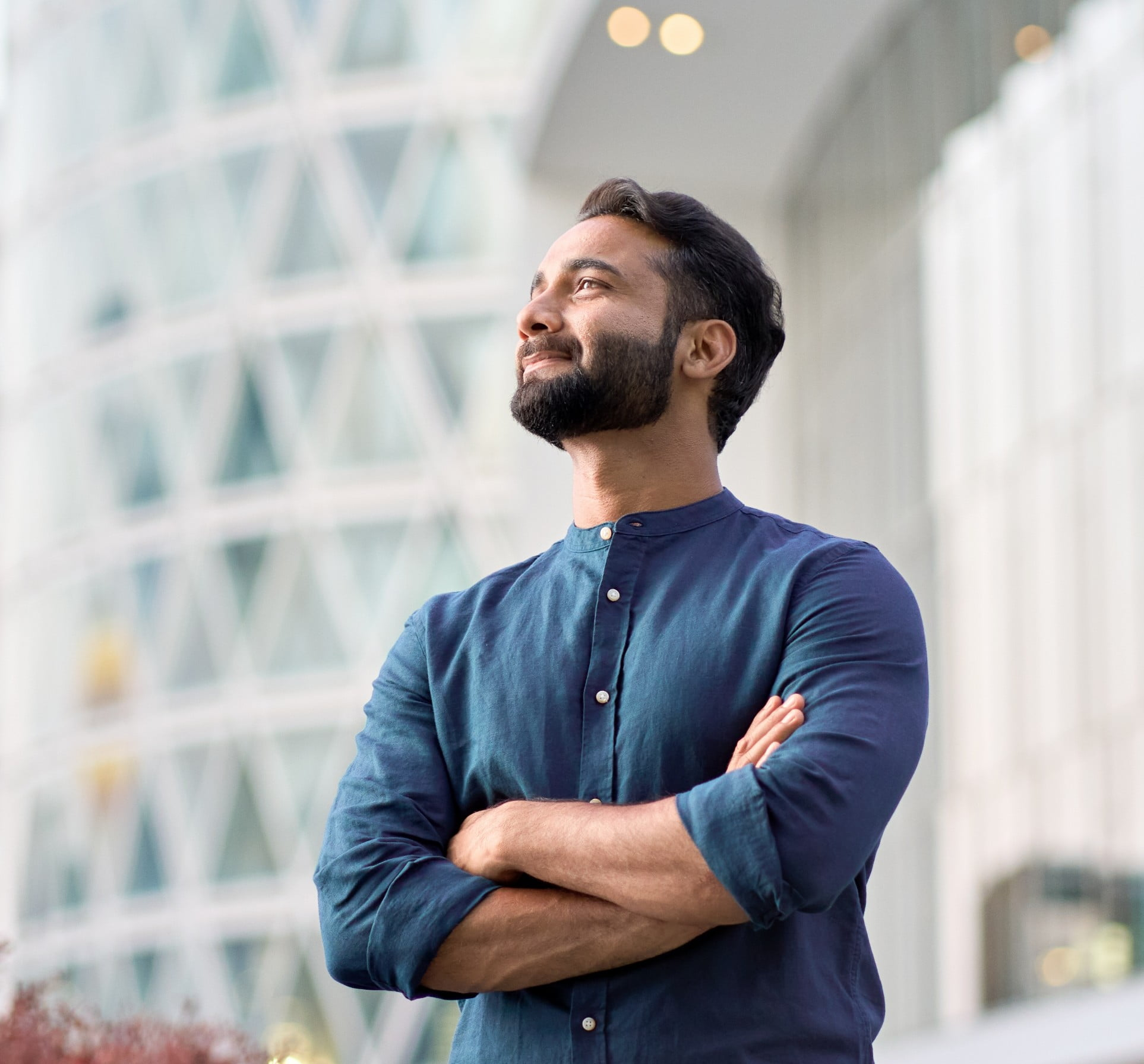 A picture of a man with his arms crossed looking off in the distance